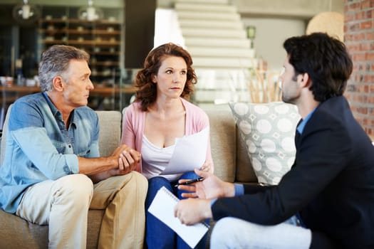 Mature couple, worried and lawyer with documents for mortgage for debt for planning, finances and advice. Man, woman and consultant for pension, offer or agreement in lounge with advisor in home.