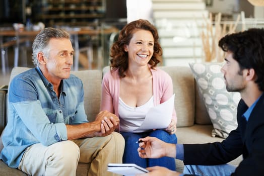 Mature couple, broker and documents in house for mortgage for retirement in planning, finances and advice. Man, woman and consultant for pension, deal or agreement in lounge with advisor in home.