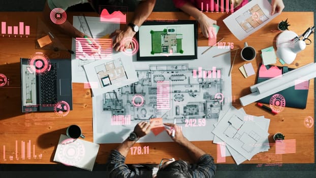 Top down view of engineer planning and writing at blueprint. Architect team working together to design building construction while sitting at meeting table with financial chart holographic. Symposium.