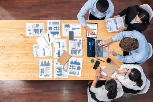 Panorama top view diverse group of business analyst team analyzing financial data report paper on meeting table. Chart and graph dashboard by business intelligence analysis. Meticulous