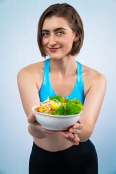Full body length gaiety shot athletic and sporty young woman with healthy vegan food in standing posture on isolated background. Healthy active and body care by vegetarian lifestyle.