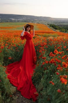 Woman poppy field red dress hat. Happy woman in a long red dress in a beautiful large poppy field. Blond stands with her back posing on a large field of red poppies