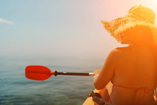 A woman wearing a straw hat is paddling a canoe on a sunny day. Scene is relaxed and carefree, as the woman enjoys her time on the water