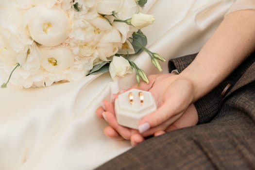 A couple holding a white box with two rings inside