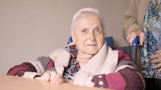 Senior woman looking at camera sitting in wheelchair a geriatric