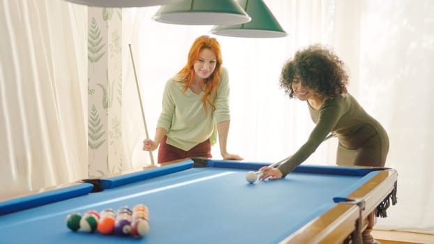 Two women starting to play pool at home