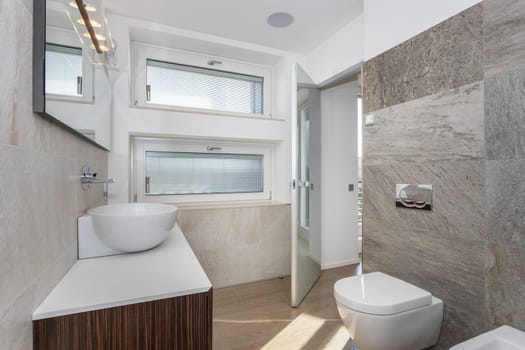 Elegant and modern bathroom of a luxury house, with wooden floor.