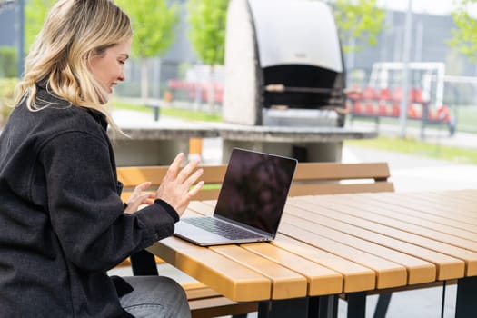 Young woman with laptop outside. High quality photo
