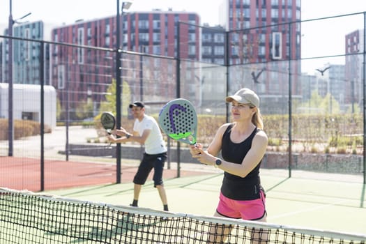 Ukraine Kyiv, April 02 2024. Padel training coach in a session, mentoring a female student, fostering skill development and a positive learning environment. High quality photo