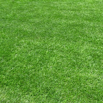 Synthetic grass background. Surface of fake green grass for background or backdrop.