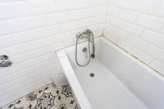 Interior of narrow restroom with wall hung toilet with white walls and checkered floor. High quality photo
