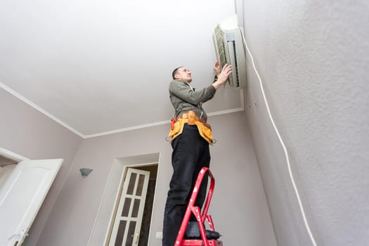 Male technician cleaning air conditioner indoors. High quality photo