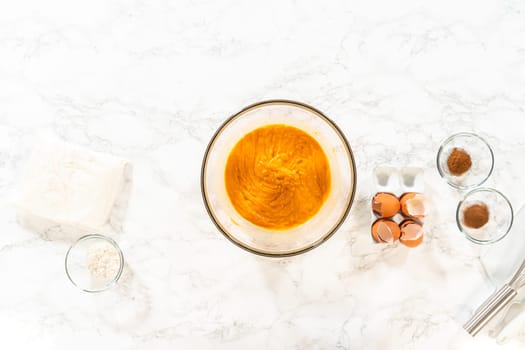 Flat lay. In a cozy kitchen, a large mixing bowl becomes the stage for expertly blending the ingredients, setting the scene for crafting a delightful homemade pumpkin bundt cake from cake mix.