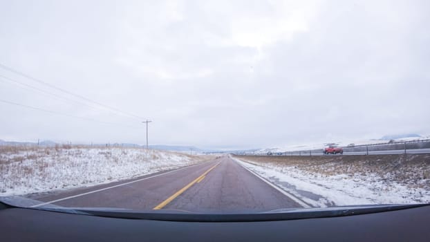 The open highway invites a peaceful drive, with snow-clad pines lining I-25 as the journey continues from Denver towards Colorado Springs on a snowy day.