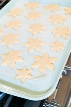 Letting delightful snowflake-shaped sugar cookies cool after baking, preparing them for festive Christmas gifts.
