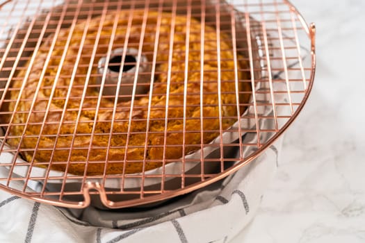 Cooling freshly baked pumpkin bundt cake on the kitchen counter.