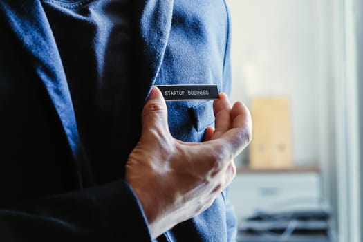 businessman holding a startup business label in his hand, business concept