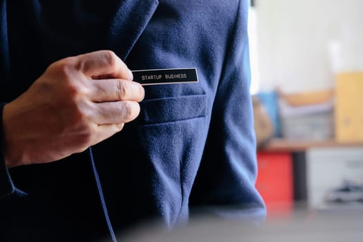 businessman holding a startup business label in his hand, business concept