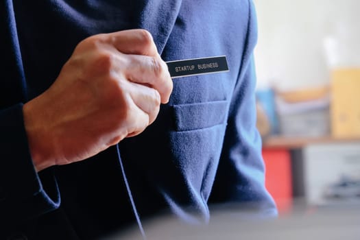 businessman holding a startup business label in his hand, business concept