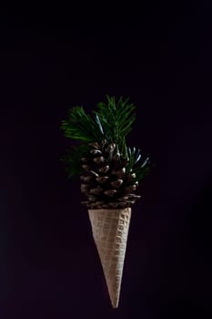 A cone shaped ice cream cone with pine needles on top.