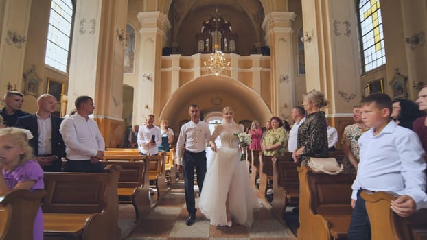 A father takes his daughter to a wedding in a Catholic church