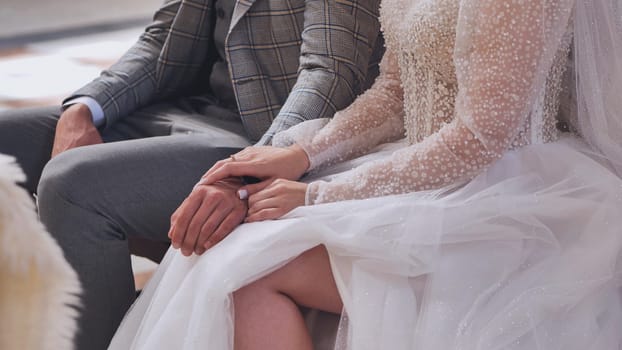 Close-up hands of the bride and groom in a Catholic church