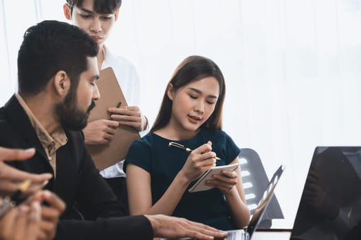 Happy diverse business people work together, discussing in corporate office. Professional and diversity teamwork discuss business plan on desk with laptop. Modern multicultural office worker. Concord