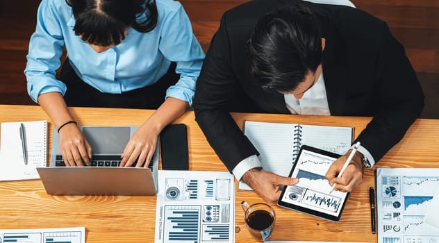 Top view diverse group of business analyst team analyzing financial data report paper on meeting table. Chart and graph dashboard by business intelligence analysis. Meticulous