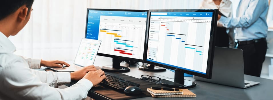 Project management team coordinating and update project planned schedule on computer using Gantt chart software in office. Business people planning time and deadline for company task. Trailblazing