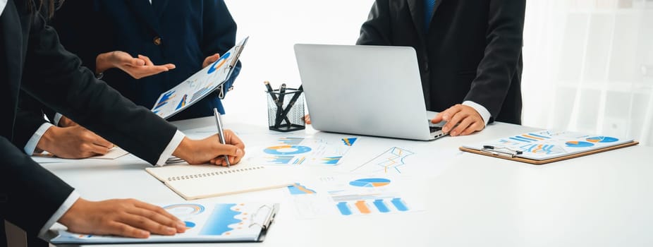 Business people in group meeting in formal attire share idea discussing report for company profit in creative workspace for start up business shot in close up view on group meeting table . Oratory .