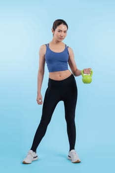 Vigorous energetic woman doing kettlebell weight lifting exercise on isolated background. Young athletic asian woman strength and endurance training session as body workout routine.