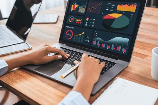 Multiracial analyst team use BI Fintech software to analyze financial data on meeting table. Financial dashboard data display on laptop screen with analyzed chart for marketing indication. Concord