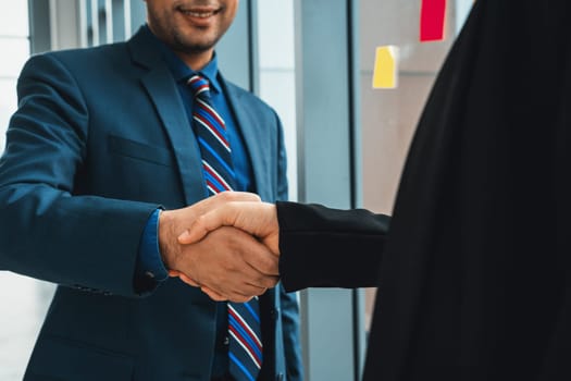 Business people handshake in corporate office showing professional agreement on a financial deal contract. Jivy