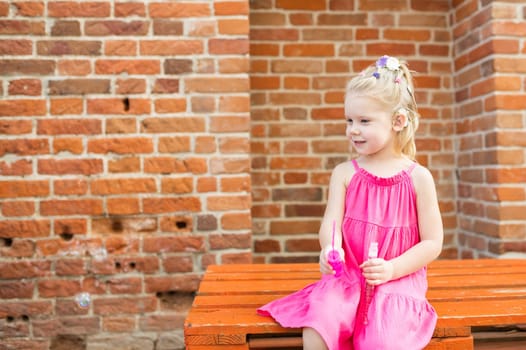 Child girl with hearing aids and cochlear implants having fun outdoor speak and playing. Copy space and empty place for advertising.