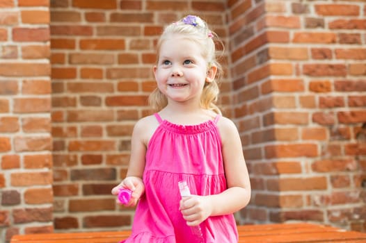 Child girl with hearing aids and cochlear implants having fun outdoor speak and playing. Copy space and empty place for advertising.