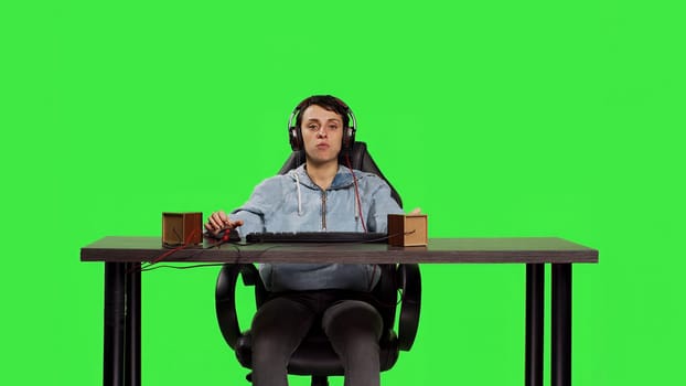 Woman being excited about winning online gaming championship, playing video games on computer sitting at desk. Gamer having fun celebrating her success and victory, greenscreen backdrop. Camera B.