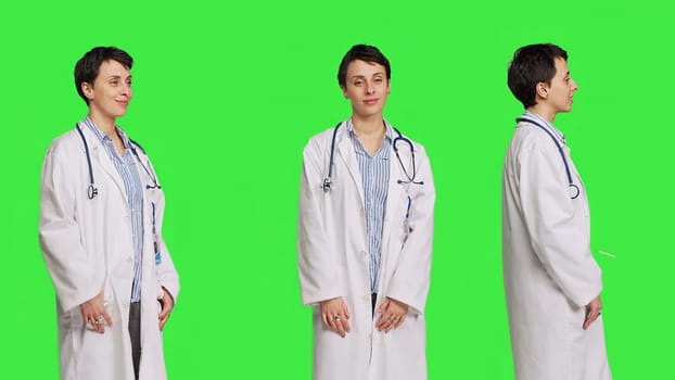 Portrait of physician wearing a white coat and a stethoscope for exams, standing against greenscreen backdrop. Doctor specialist working in healthcare industry, medical expertise. Camera B.