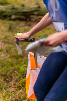 A woman punching at the orienteering control point close up. Female in forest checking to a control point. Selective focus