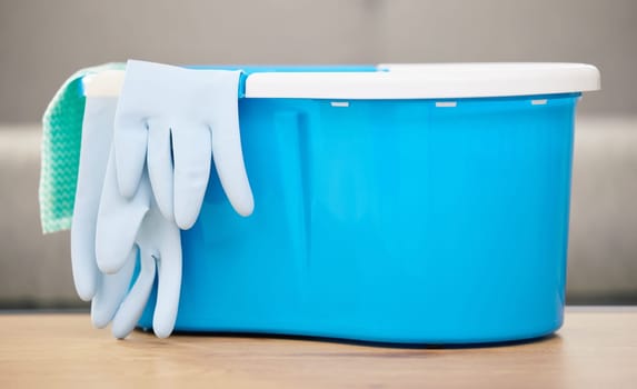 Cleaning cloth, bucket and gloves on table with materials for washing, mopping and spring clean in living room. Housekeeping, chores and supplies for hygiene, sanitation and cleanliness in home.