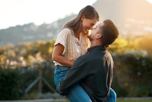 Man, woman and carry with laughing in park for marriage anniversary or funny joke, love or romance. Happy couple, pick up and embrace in backyard for partnership travel on date, vacation or summer.