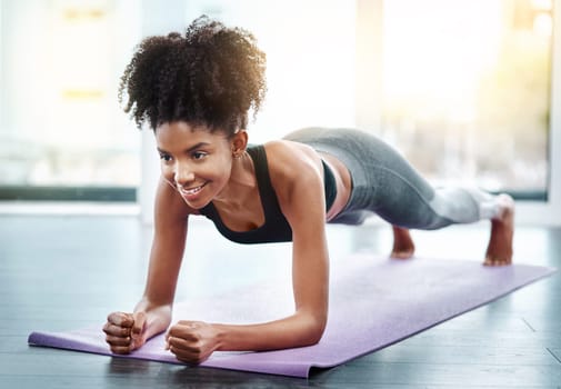 African woman, gym and plank for fitness on mat, core exercise and health club for body or strong abdomen. Balance, sportswear and muscles for wellness or training, happy athlete in pilates workout.