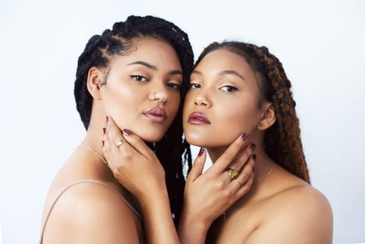 Lgbtq, makeup and portrait of women in studio for love, beauty and support on white background. Couple, serious and lesbian with embrace in pride for dermatology, solidarity and cosmetics together.