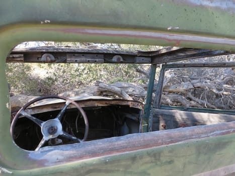 Looking Inside at the Steering Wheel in an Abandoned Old Car in the Desert. High quality photo