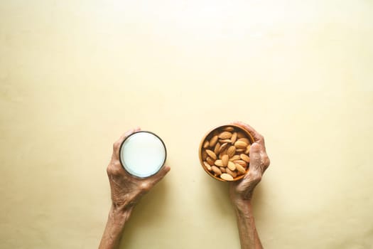 close up senior women hand holding a bowl on almond .