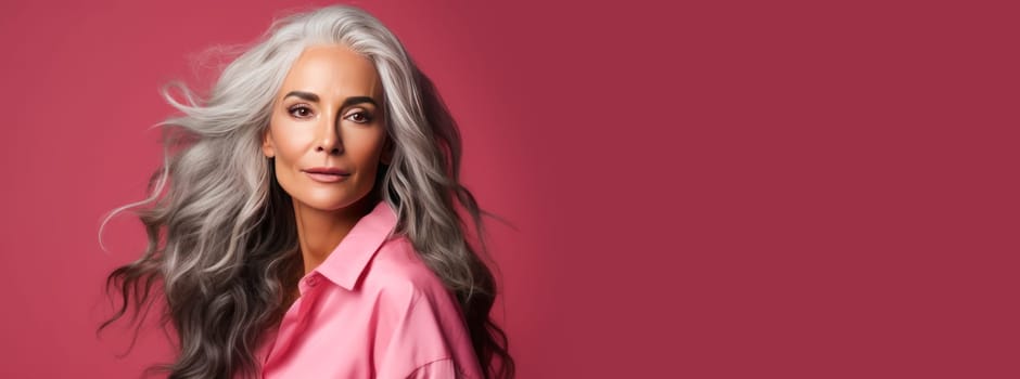 Elegant, elderly, chic Latino, Spain woman with gray long hair and perfect skin, pink background, banner. Advertising of cosmetic products, spa treatments, shampoos and hair care products, dentistry and medicine, perfumes and cosmetology for women