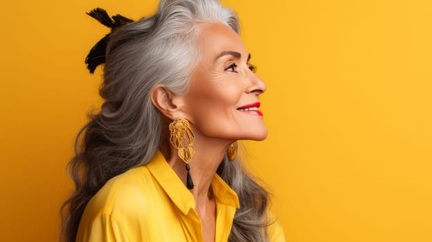 Elegant, elderly, chic Latino, Spain woman with gray long hair and perfect skin, yellow background, banner. Advertising of cosmetic products, spa treatments, shampoos and hair care products, dentistry and medicine, perfumes and cosmetology for women