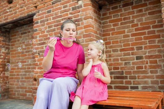 Child girl with cochlear implant with her mother spend time outdoor. Hear impairment and deaf community concept. Deaf and health concept. Diversity and inclusion. Copy space.