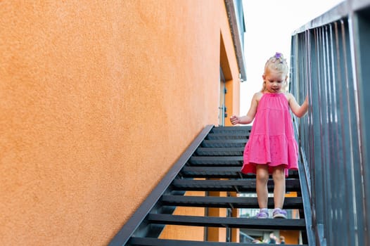 Child girl walks and have fun outdoor with cochlear implant on the head. Hearing aid and treatment concept. Copy space vertical.