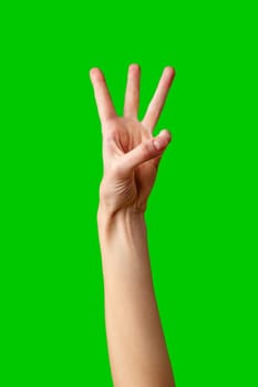 A persons arm is extended upwards with their hand showing the number three, by holding up three fingers in a commonly recognized gesture against a vibrant green backdrop.