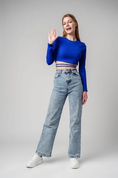 Young Woman in Blue Top Making Hand Gesture in studio